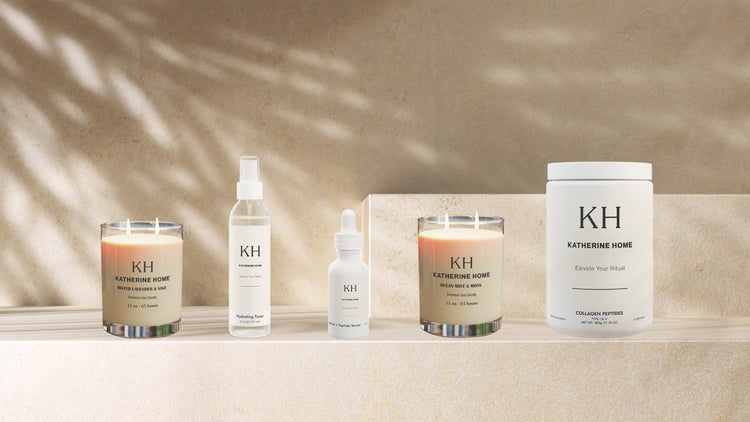 A curated selection of Katherine Home candles, skincare, and supplements displayed together in a luxury lifestyle setting.