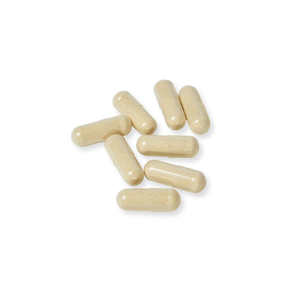 A handful of vegetable capsules arranged on a white background to showcase shape and color.