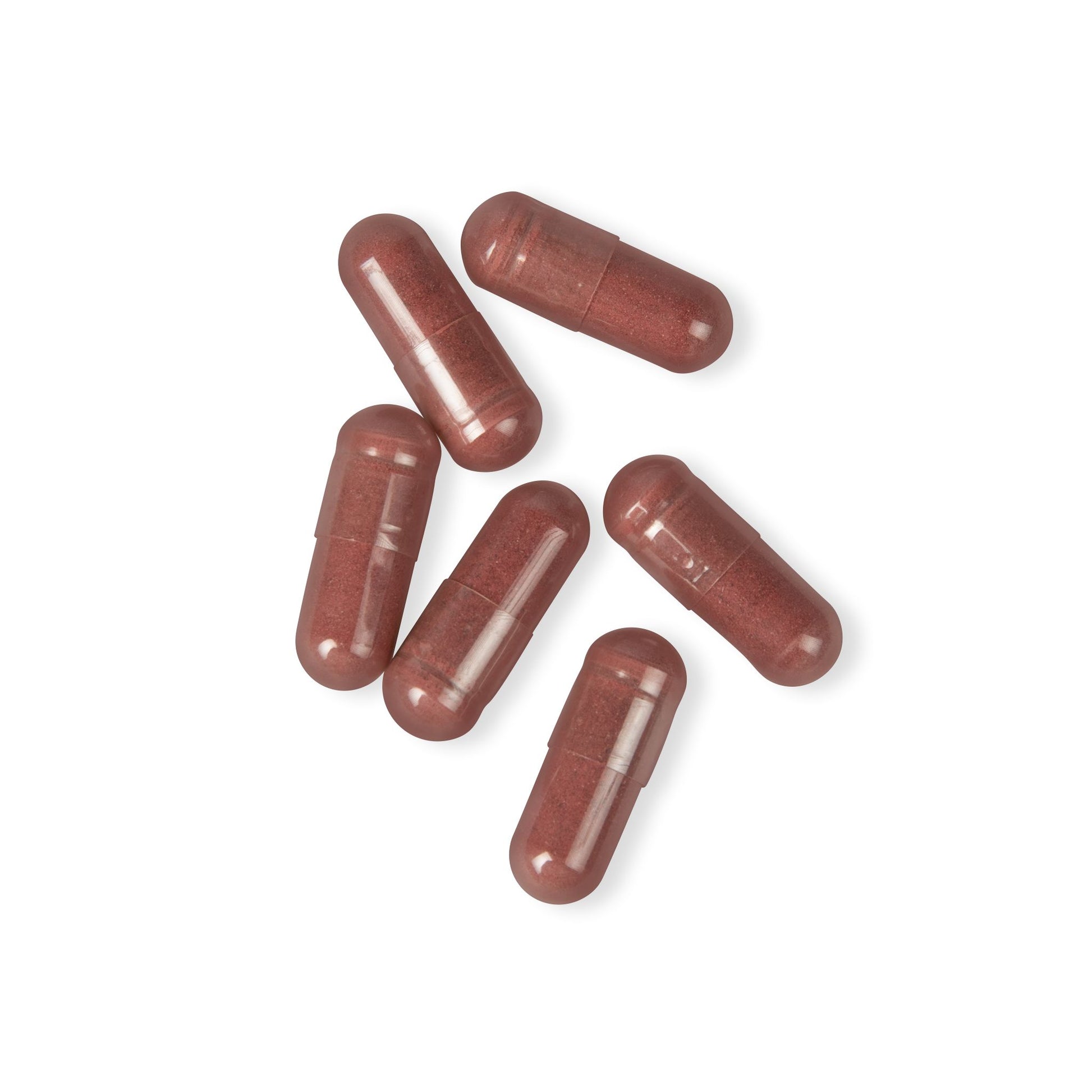 Loose beetroot capsules arranged on a clean white surface showing size and texture.
