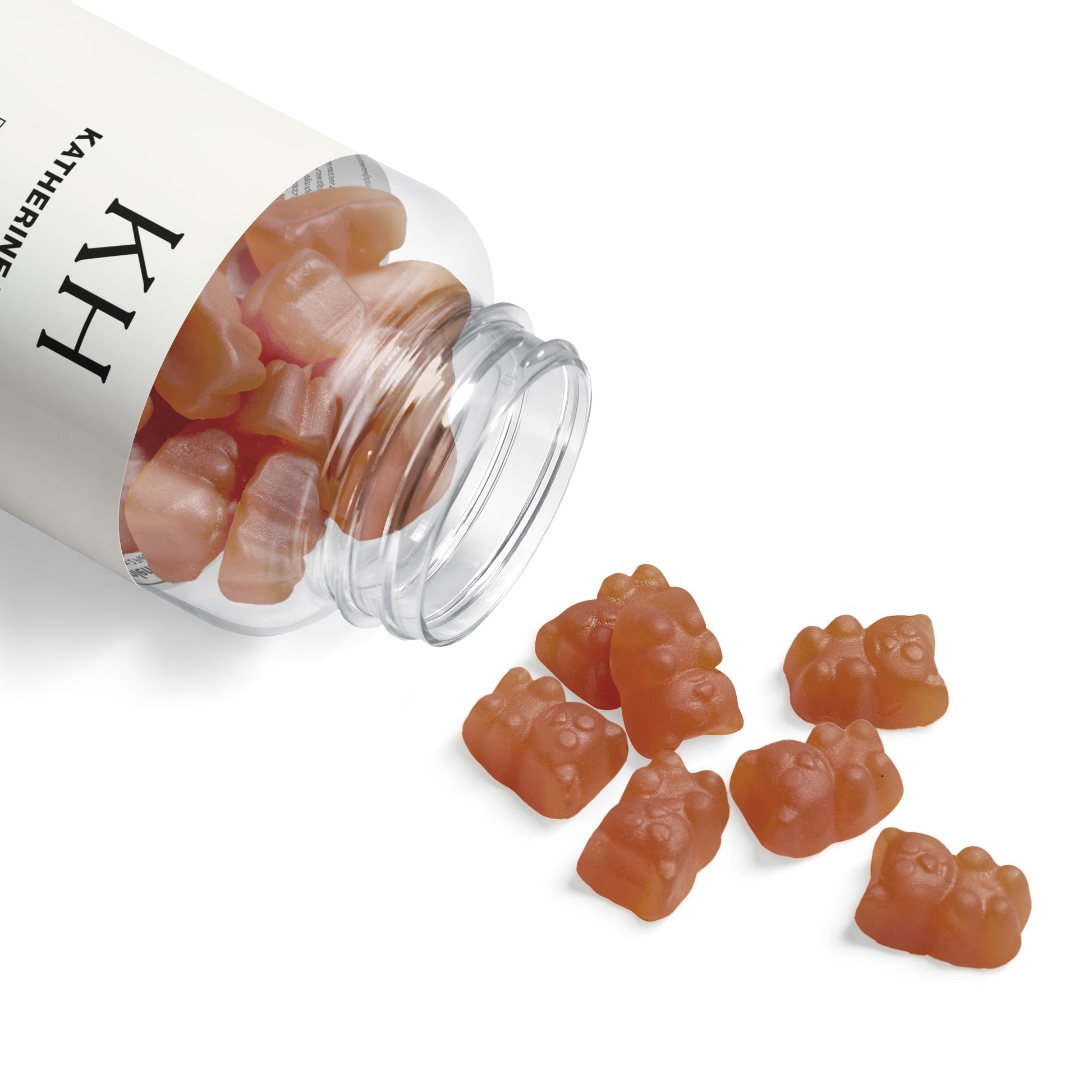 Open bottle with collagen gummies spilled on a white surface, showcasing shape and soft texture.