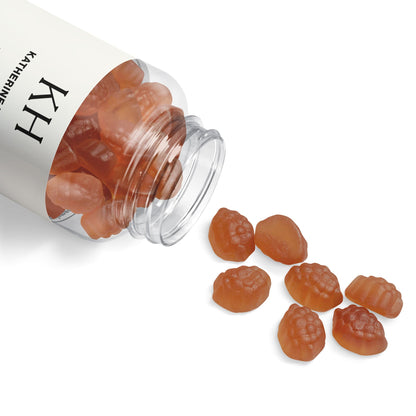 Lifestyle image of KH Sleep Well Gummies gently spilled from the open bottle onto a clean white surface, highlighting gummy shape and texture.